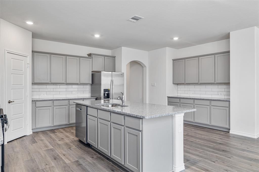 10305 Rambling Brks Lane Aubrey, TX 76227 - Photo 13 of 28 a kitchen with a sink cabinets and wooden floor