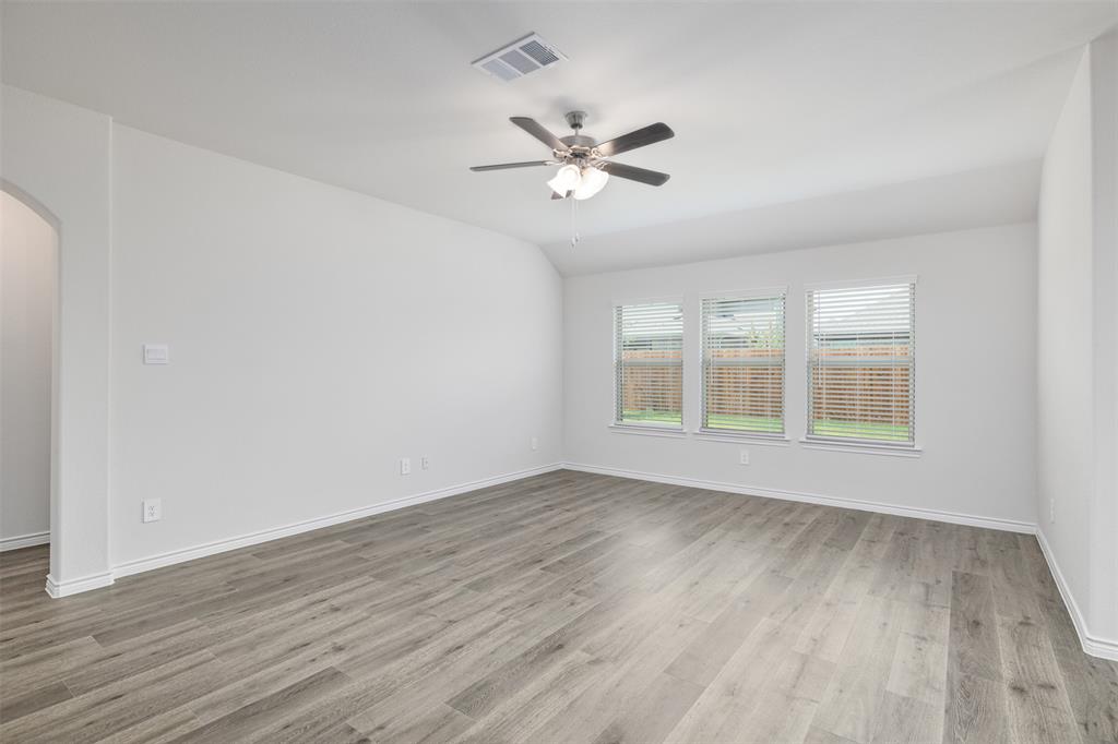 10305 Rambling Brks Lane Aubrey, TX 76227 - Photo 16 of 28 a view of an empty room with wooden floor and a window