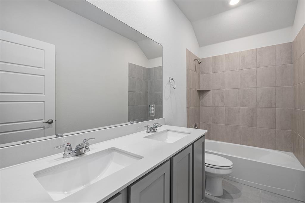 10305 Rambling Brks Lane Aubrey, TX 76227 - Photo 6 of 28 a bathroom with a sink a toilet a shower and a mirror