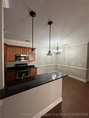 a kitchen with stainless steel appliances granite countertop a sink a stove and a refrigerator