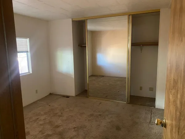 an empty room with windows and closet