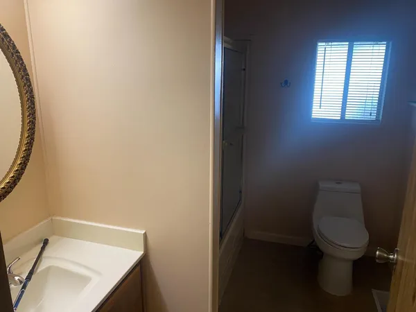 a white toilet sitting next to a bathroom sink