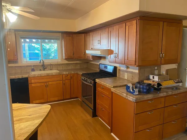 a kitchen with a stove top oven sink and cabinets