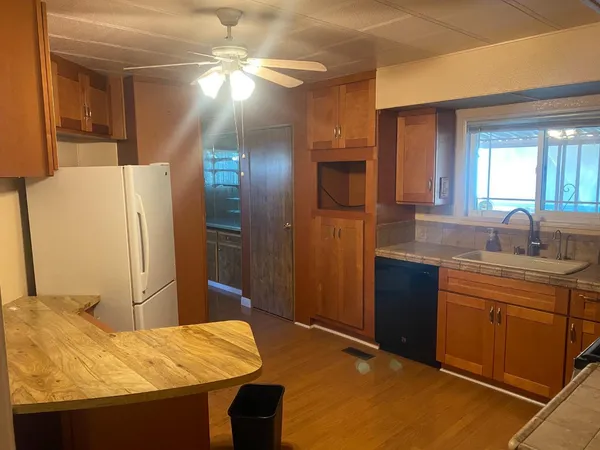 a kitchen with stainless steel appliances granite countertop a sink refrigerator and cabinets