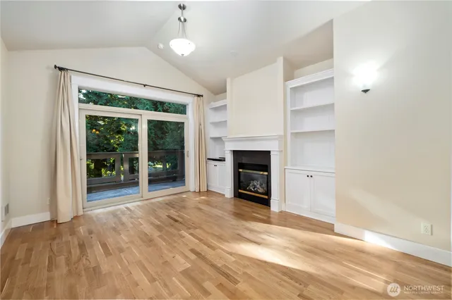 a view of an empty room with a fireplace and a window