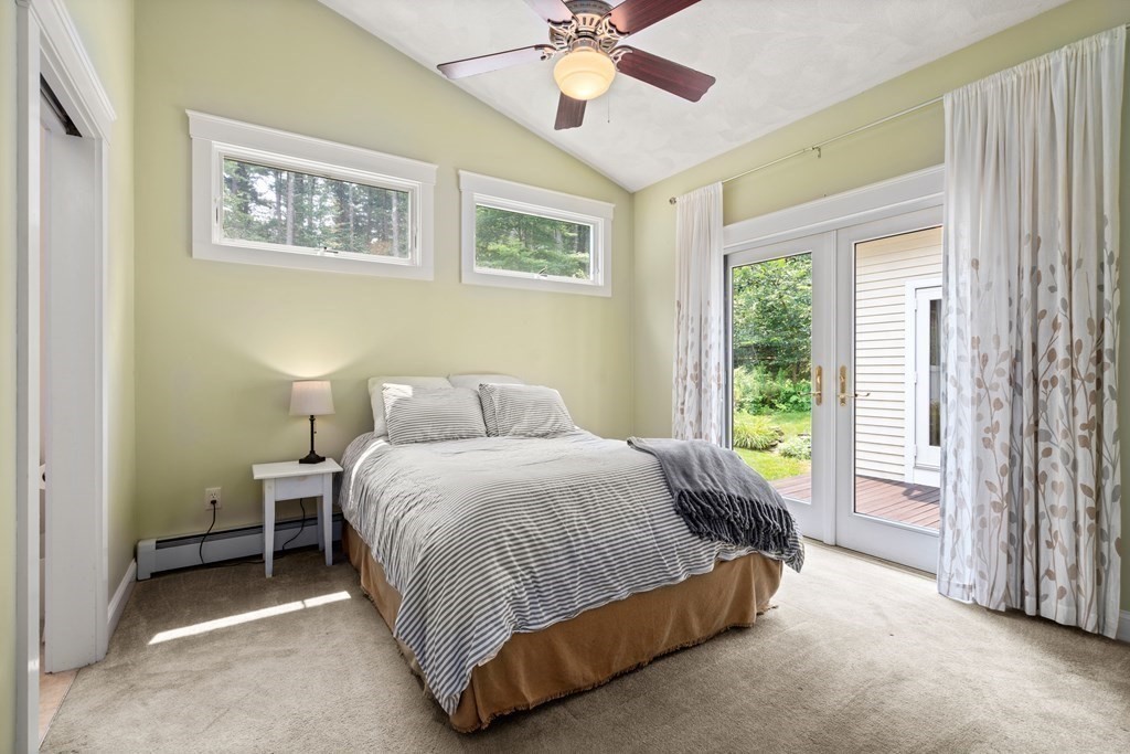 114 Still River Road Harvard, MA 01451 - Photo 36 of 42 a spacious bedroom with a bed and a chandelier