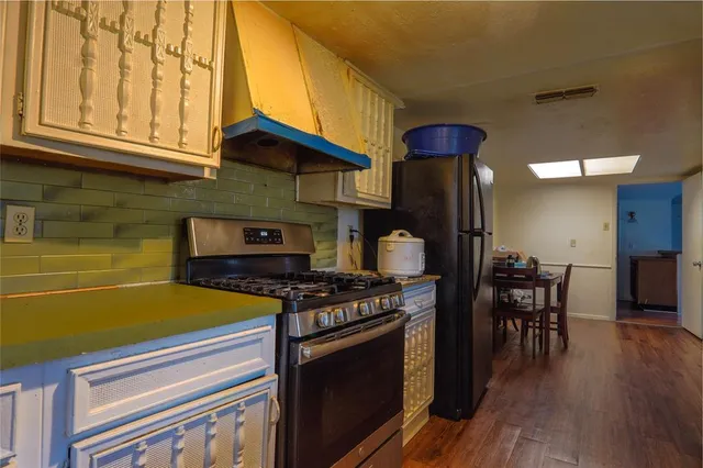 a kitchen with stainless steel appliances granite countertop a stove and a wooden cabinets