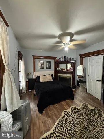 a bedroom with bed a flat tv screen and a dresser