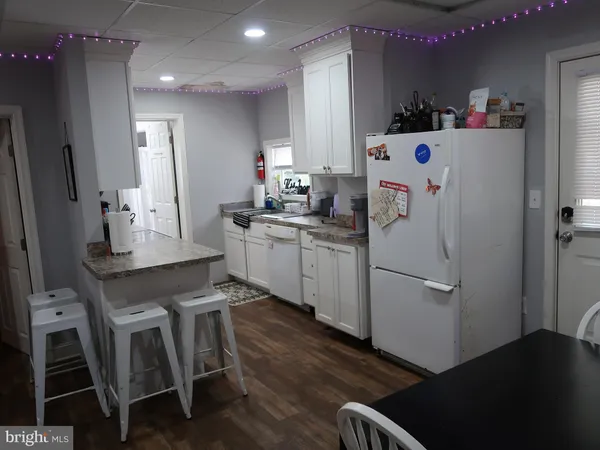 a kitchen that has a refrigerator a sink and cabinets