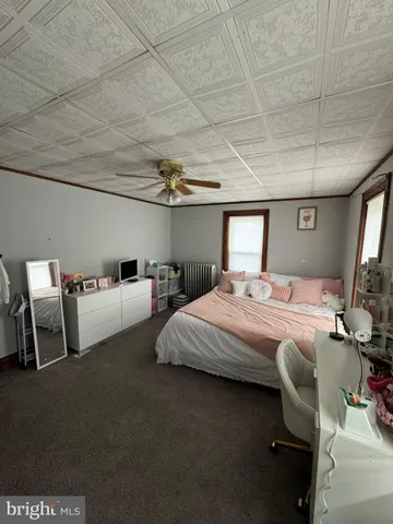 a spacious bedroom with a bed and wooden floor