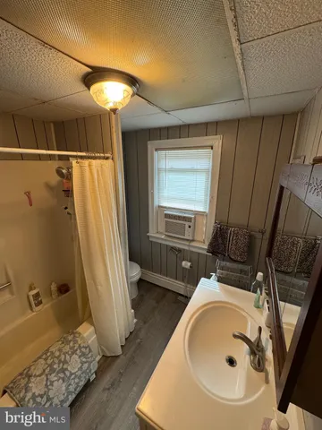 a bedroom with a bed couch and a large window