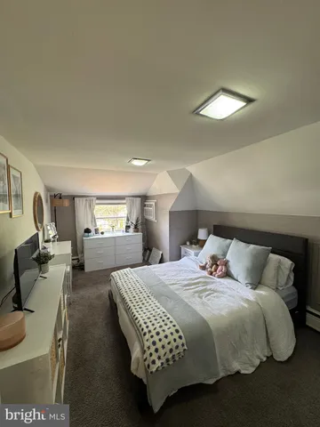 a bedroom with a bed gym equipment and a large window