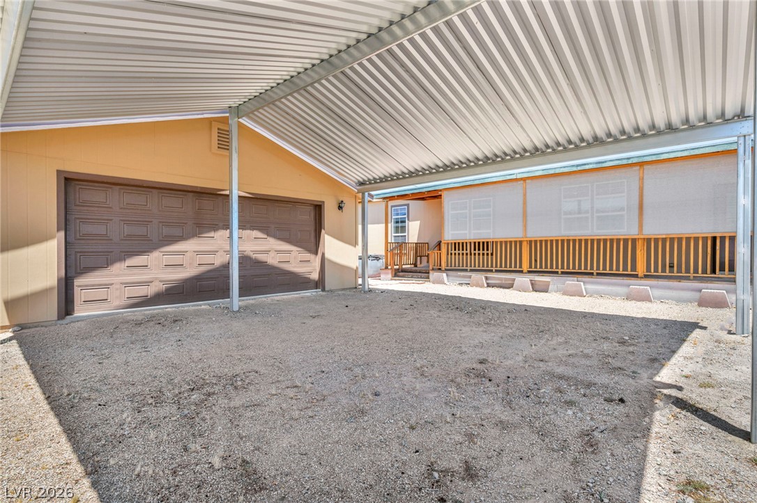 225 California Street Searchlight, NV 89046 - Photo 13 of 64 A spacious gravel driveway leads to a large attached garage and a welcoming covered porch.