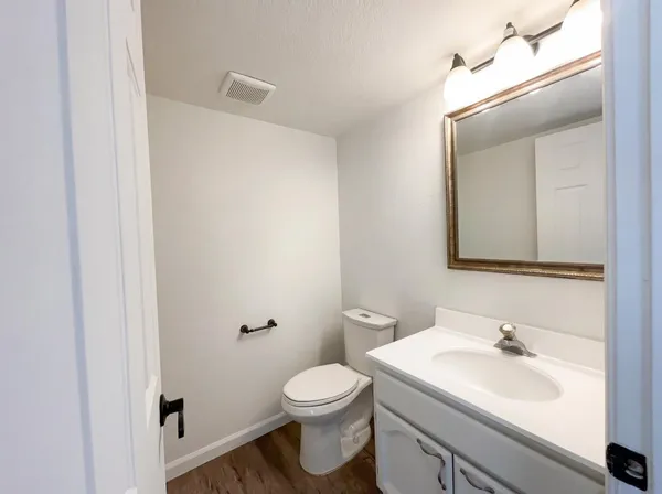 a bathroom with a sink a toilet and mirror