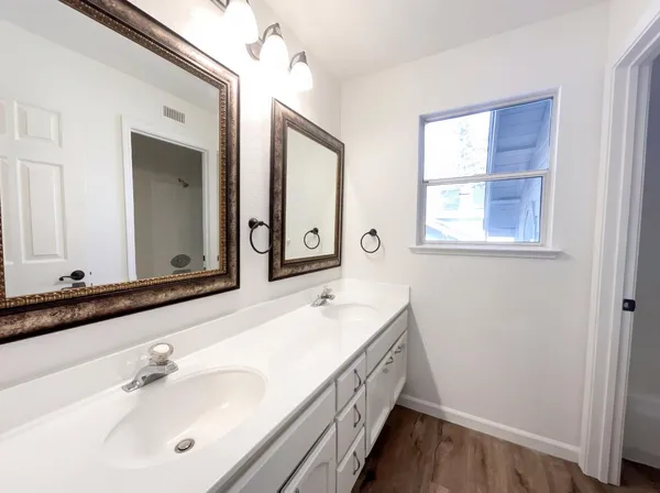 a bathroom with a double vanity sink a mirror and a