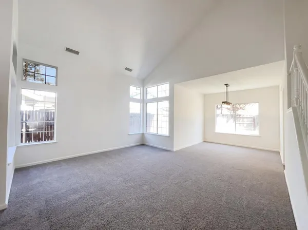 an empty room with windows and cabinet