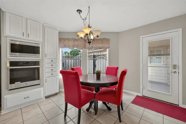 a dining room with furniture a chandelier and window
