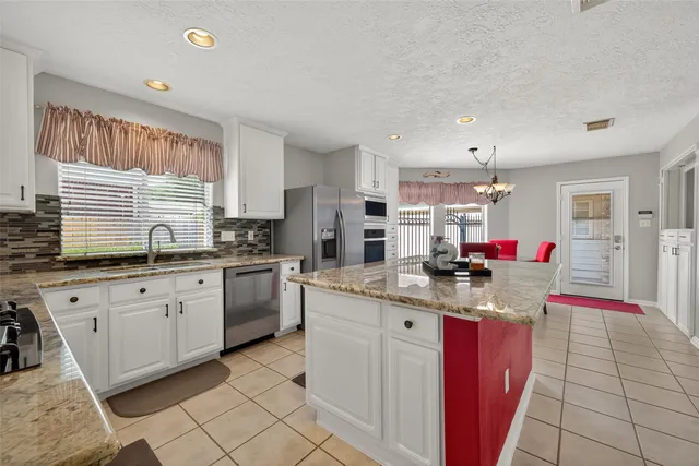 a kitchen with kitchen island granite countertop lots of counter top space and stainless steel appliances
