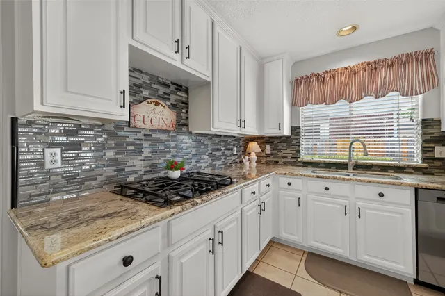 a kitchen with granite countertop white cabinets and white appliances