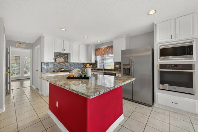 a kitchen with stainless steel appliances granite countertop a stove a sink a microwave and a refrigerator