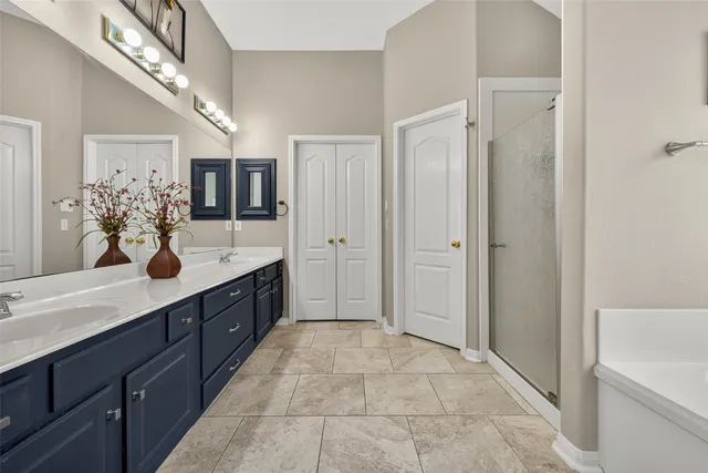 a spacious bathroom with a double vanity sink shower and a mirror