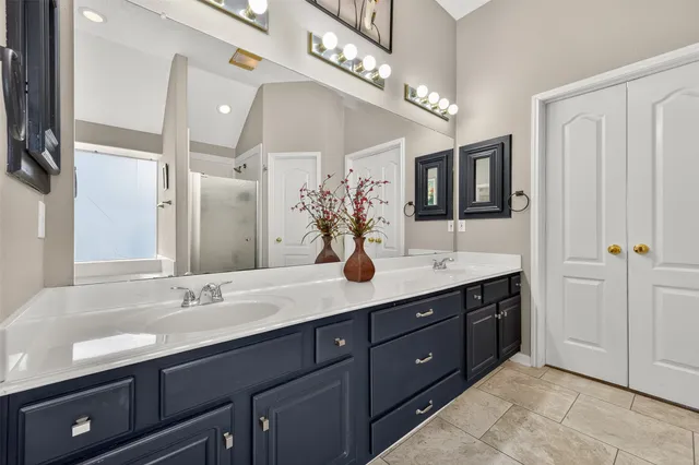 a bathroom with a granite countertop sink a large mirror and a shower