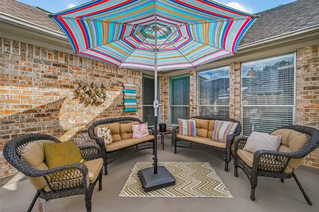 a living room with patio furniture and a rug