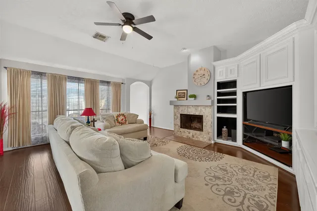 a living room with furniture a flat screen tv and a fireplace