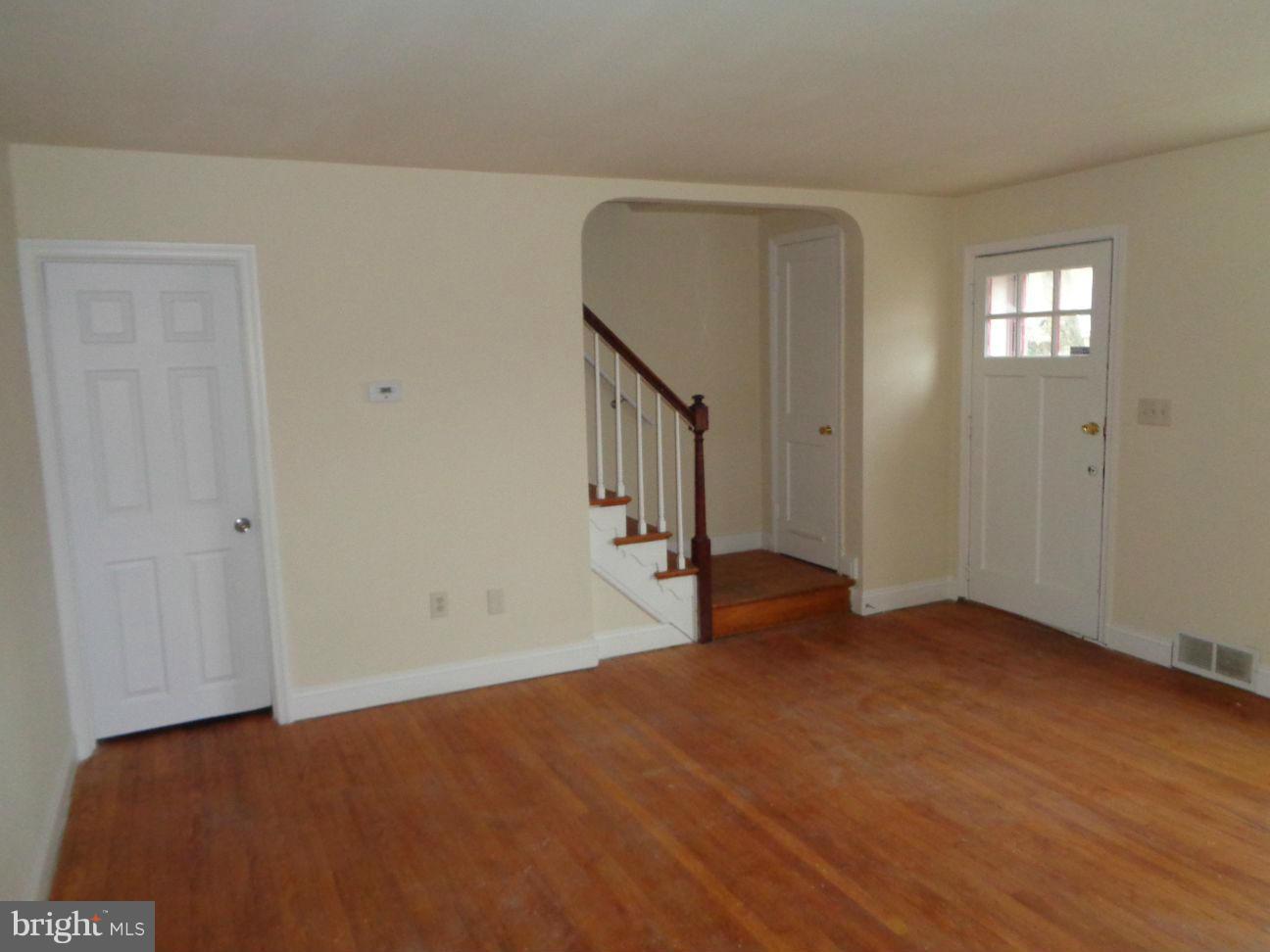 827 Wedgewood Road Baltimore, MD 21229 - Photo 2 of 22 a view of an empty room with wooden floor and windows