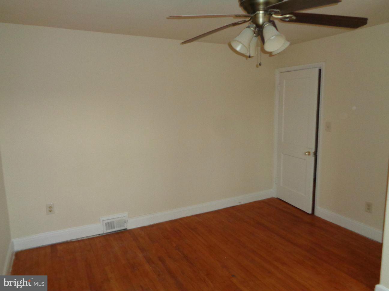 827 Wedgewood Road Baltimore, MD 21229 - Photo 15 of 22 an empty room with a hardwood and ceiling fan