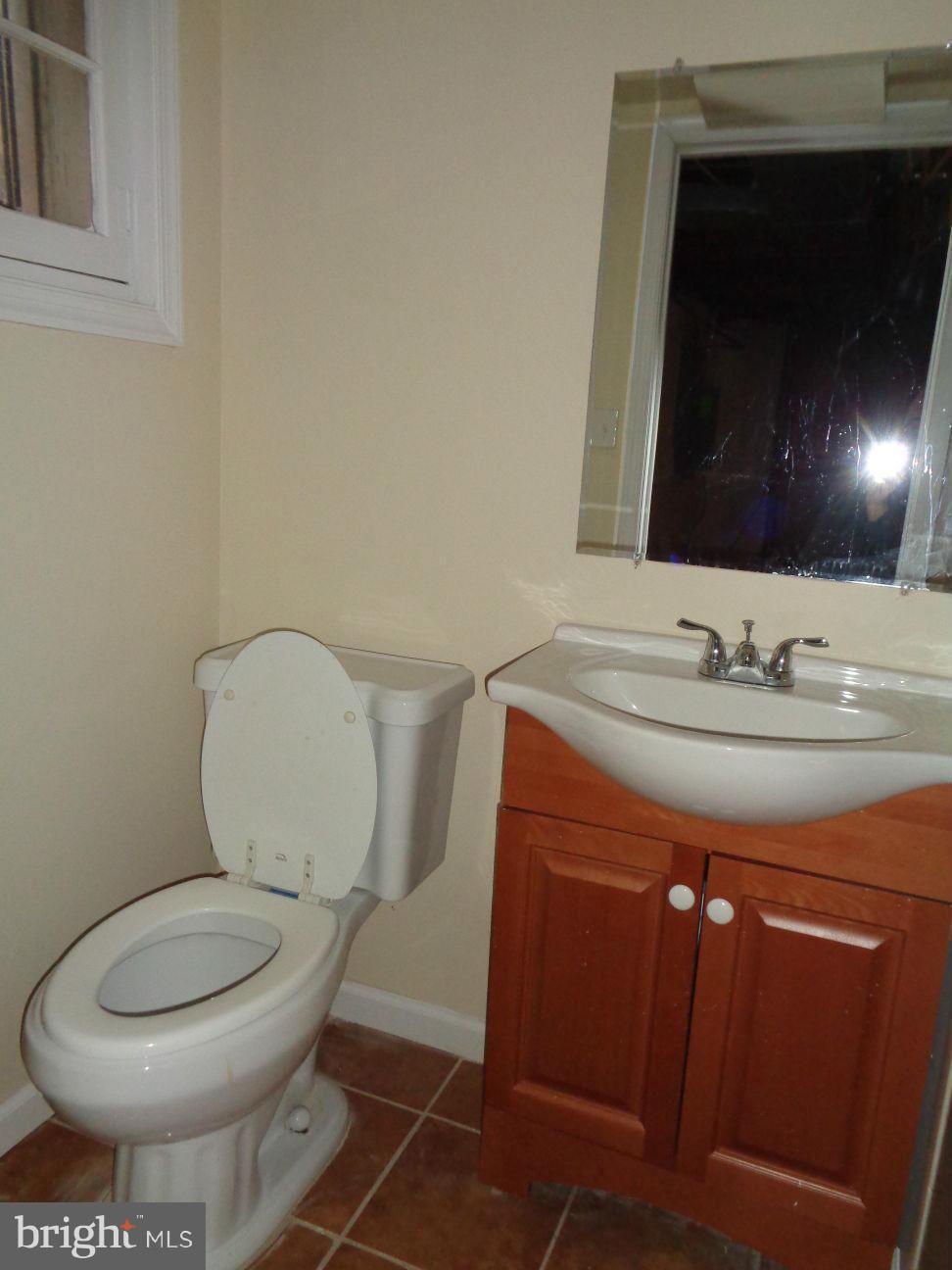 827 Wedgewood Road Baltimore, MD 21229 - Photo 20 of 22 a bathroom with a toilet a sink and mirror