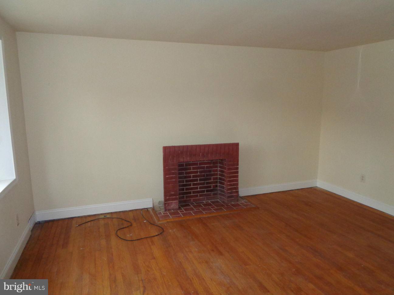 827 Wedgewood Road Baltimore, MD 21229 - Photo 3 of 22 a view of an empty room with wooden floor and a window