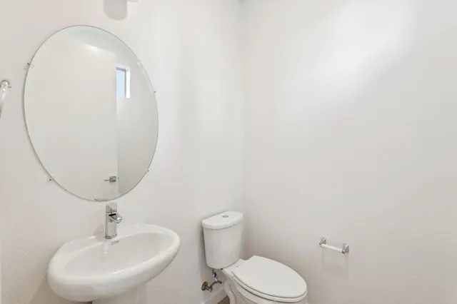 a bathroom with a sink mirror and toilet