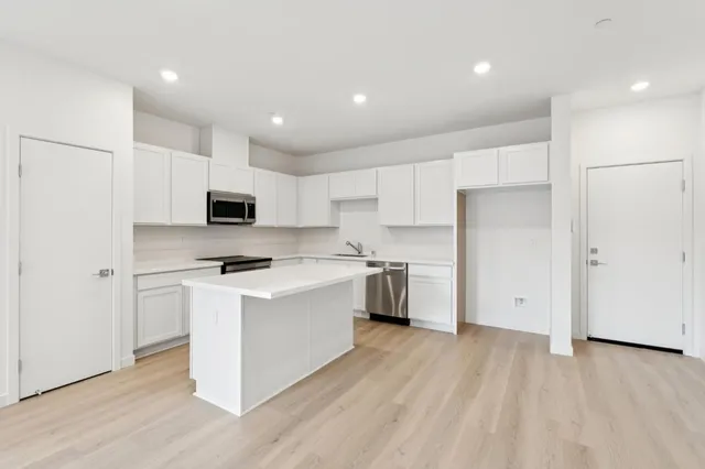 a kitchen with stainless steel appliances a white stove top oven sink and cabinets
