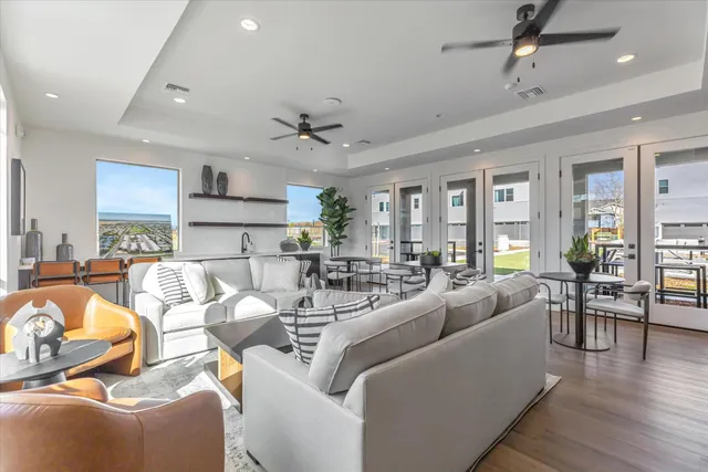 a living room with furniture kitchen view and a wooden floor