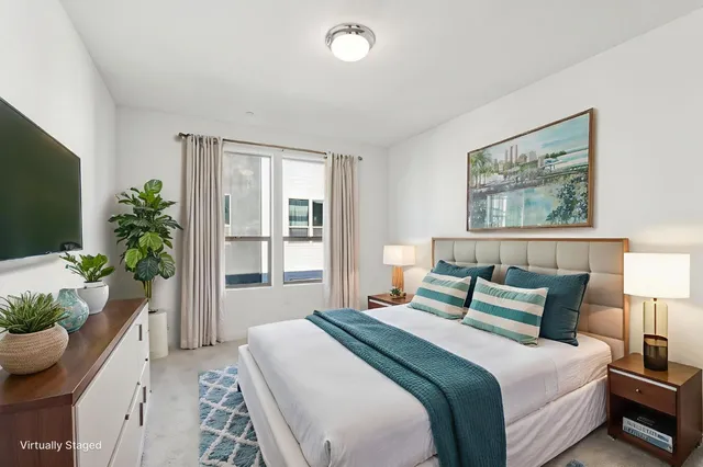 a bedroom with bed and a potted plant