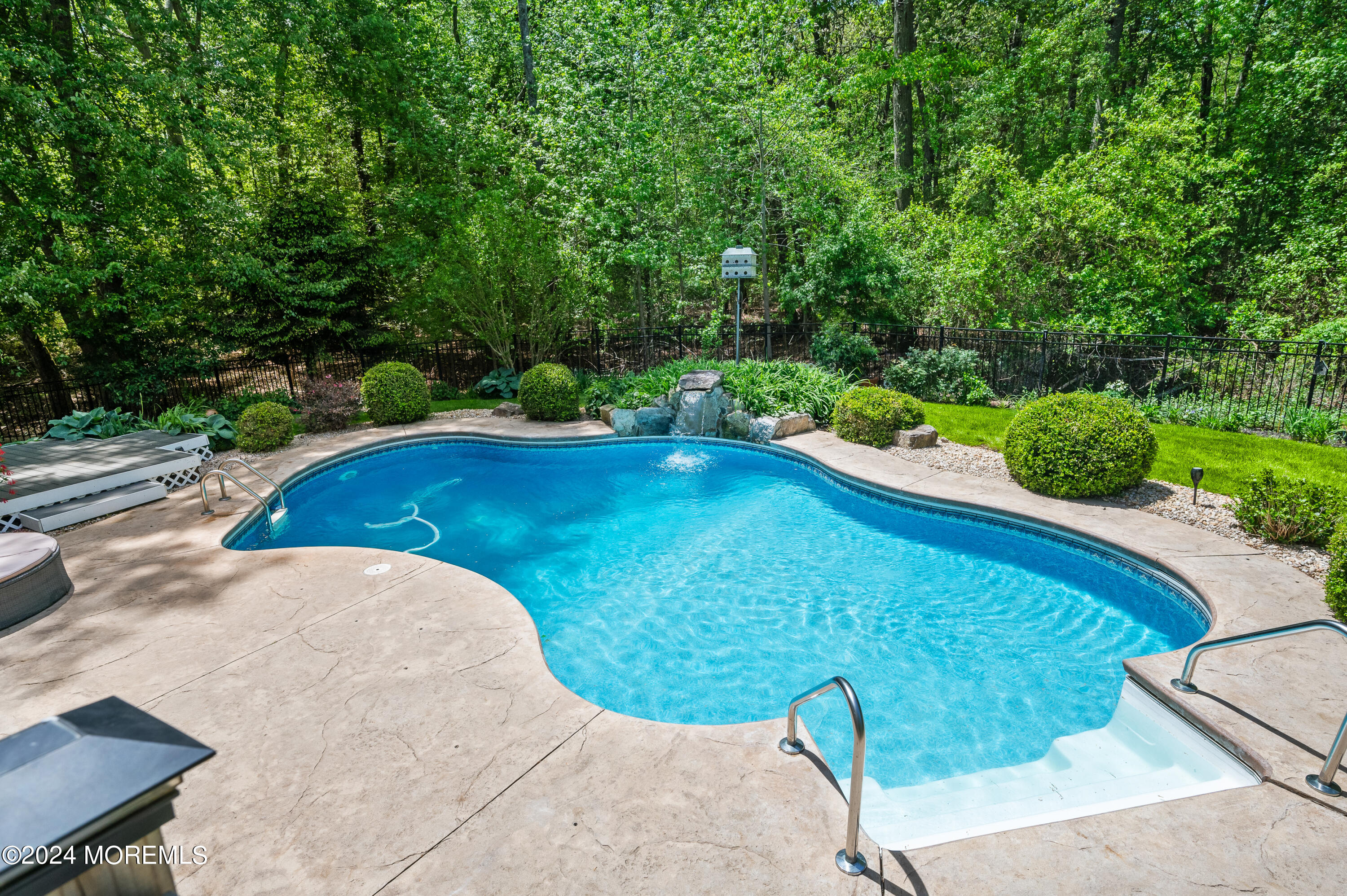 52 Danella Way Howell, NJ 07731 - Photo 37 of 42 a view of a swimming pool with lawn chairs under an umbrella