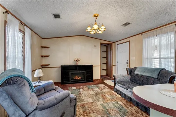 a living room with furniture a fireplace and a large window