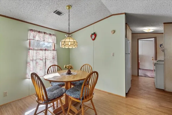 a dining room with furniture a chandelier and wooden floor