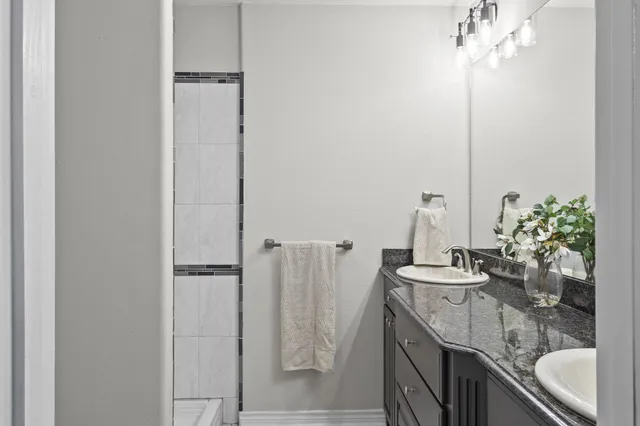 a bathroom with a granite countertop sink and a mirror