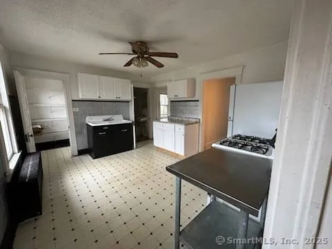 a kitchen with granite countertop a sink stove and refrigerator