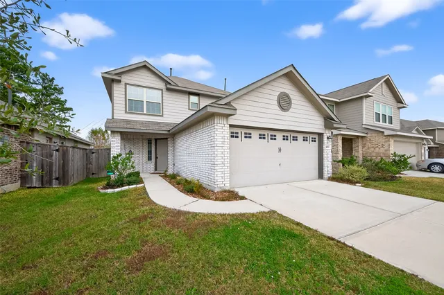 a view of a house with a yard and large tree
