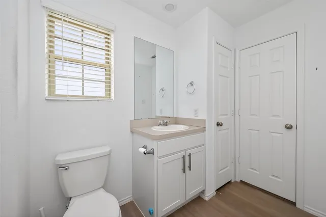 a bathroom with a sink a toilet and a window