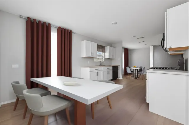 a kitchen with a table chairs refrigerator and cabinets