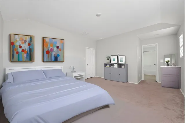 a spacious bedroom with a bed and a painting on the wall