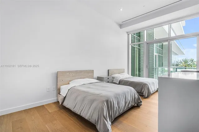 a bedroom with two beds and a large window