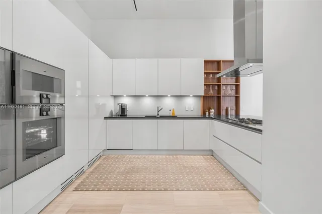 a kitchen with a refrigerator and white cabinets