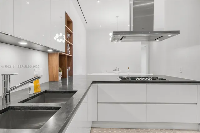 a kitchen with stainless steel appliances granite countertop a sink a stove and a microwave with granite countertops