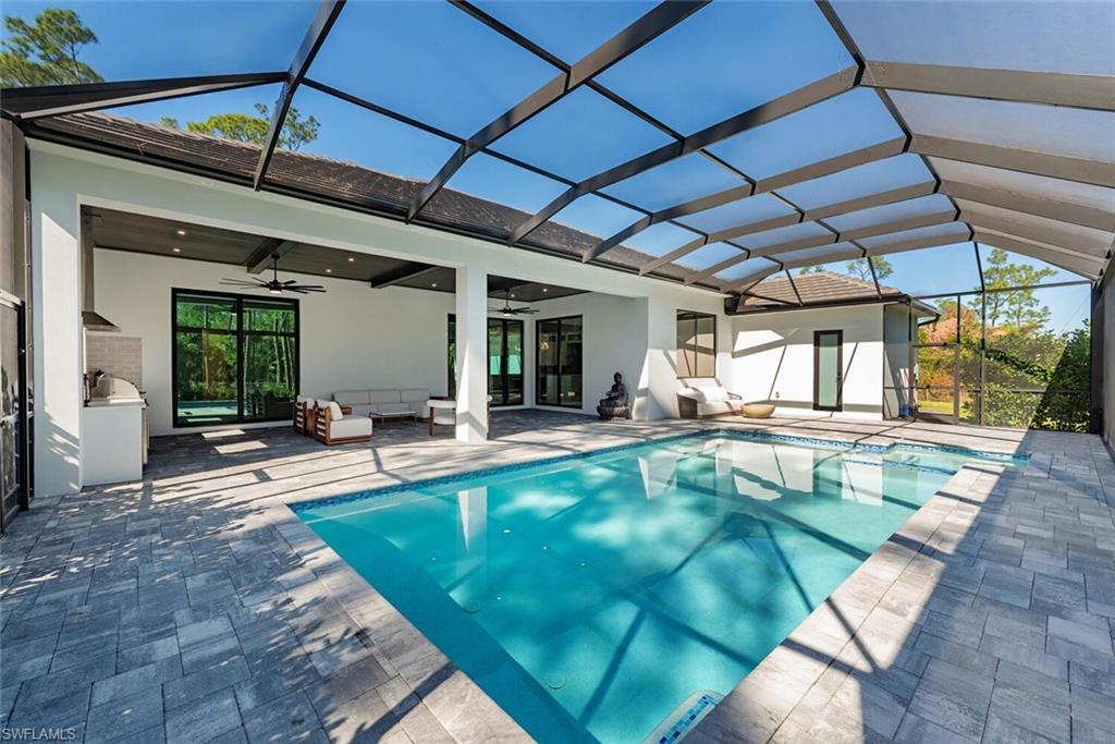 662 9th Street Southwest Naples, FL 34117 - Photo 15 of 34 a view of a backyard with swimming pool table and chairs