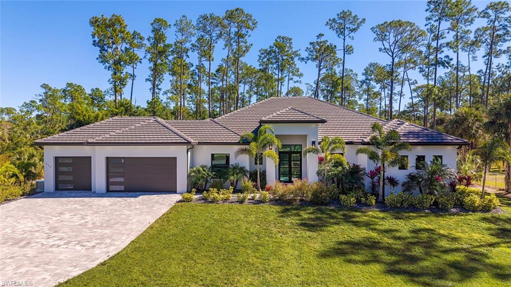 662 9th Street Southwest Naples, FL 34117 - Photo 2 of 34 a front view of a house with garden
